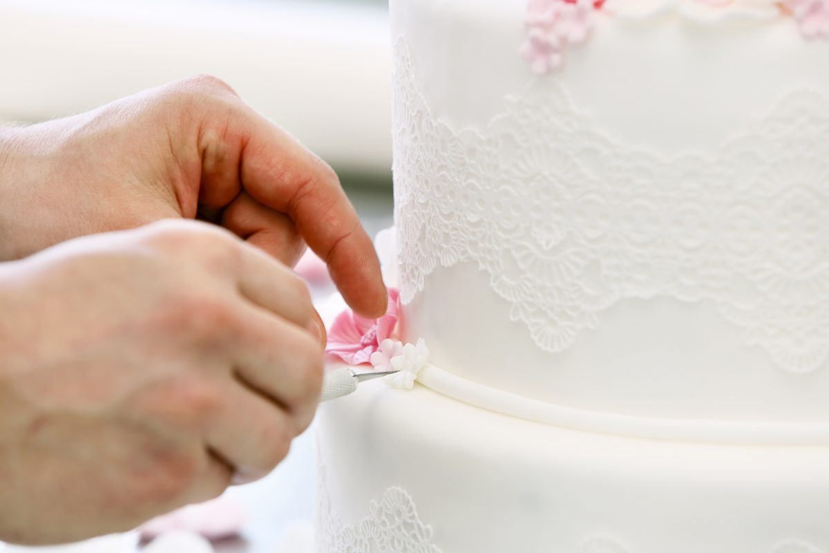 Confectioner decorates wedding cake