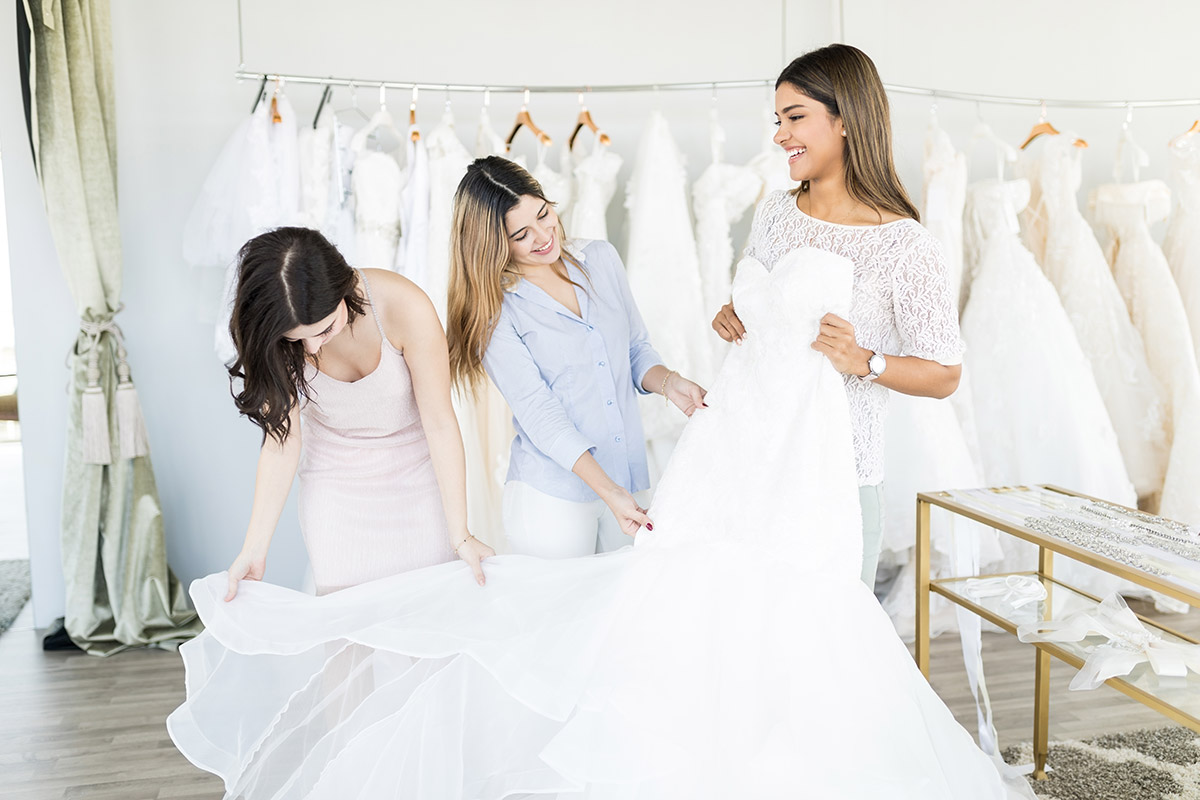 Bride and bridesmaids looking at wedding dresses  