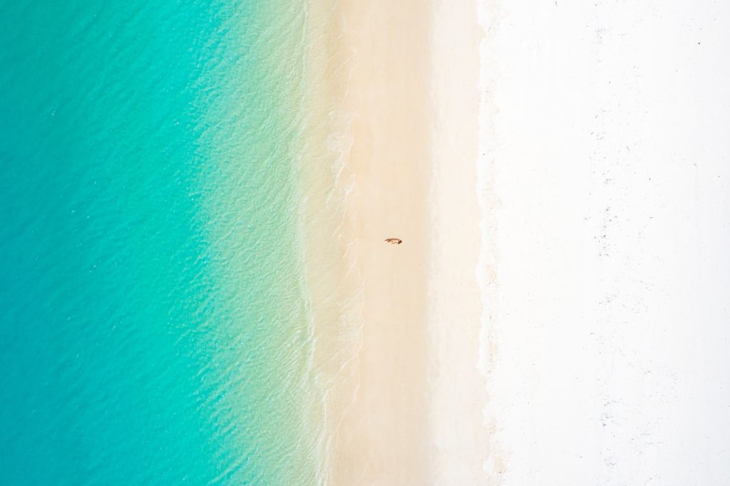woman-lying-on-white-sand-beach