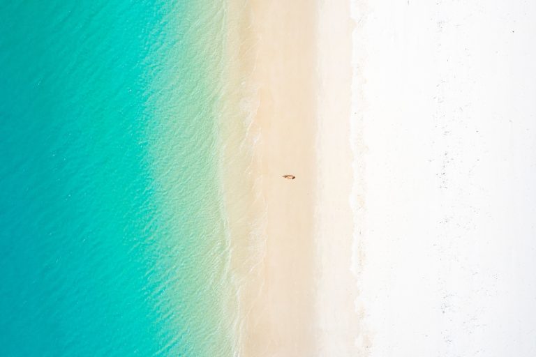woman-lying-on-white-sand-beach